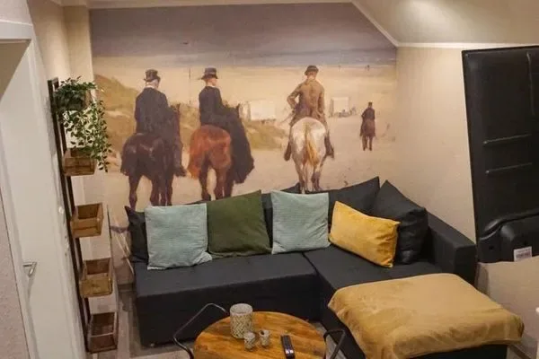Wohnbereich mit Ecksofa und Strandmotiv an der Wand