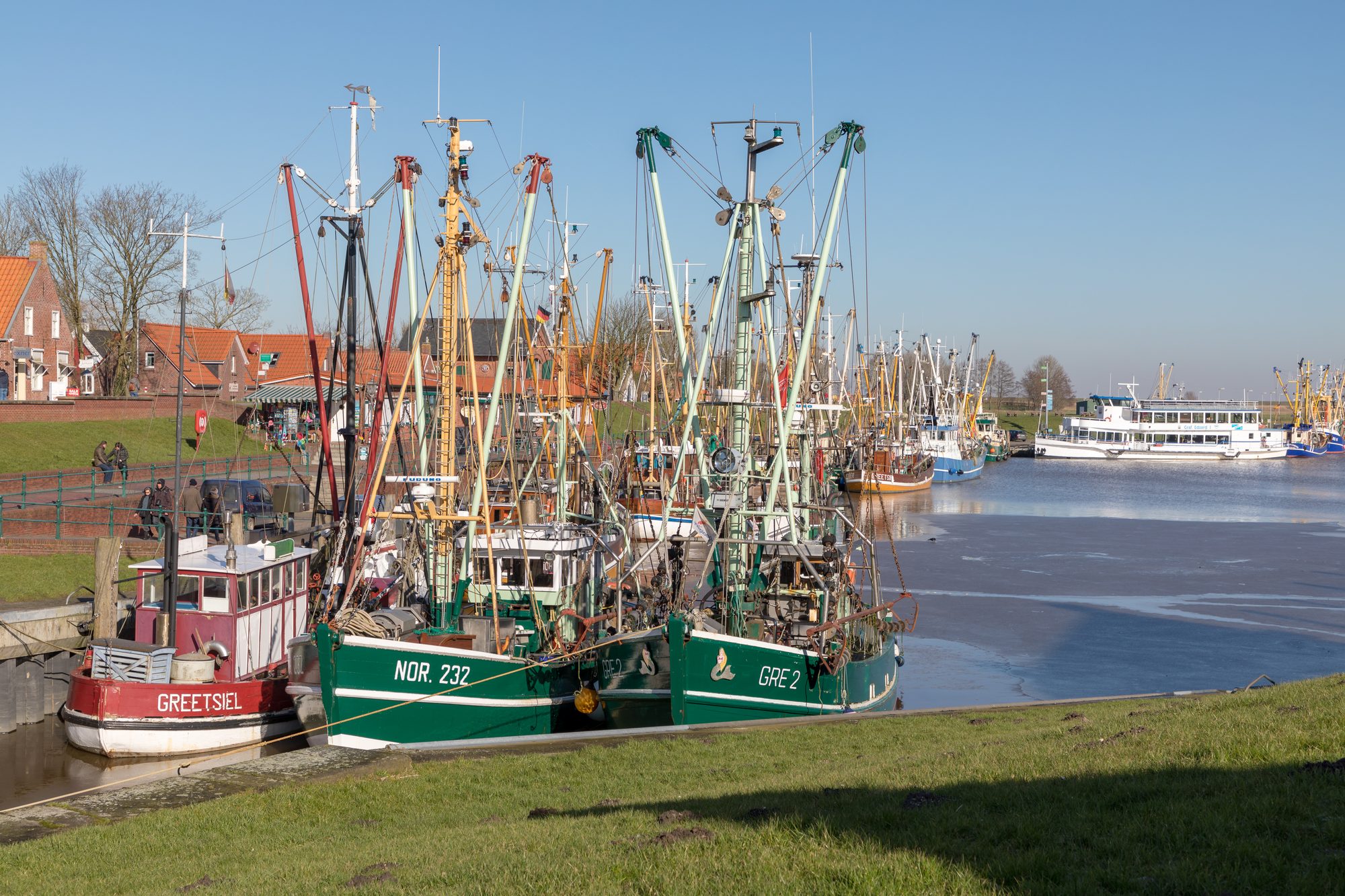 Rote und grüne Krabbenkutter im malerischen Hafen von Greetsiel nahe Grimersum
