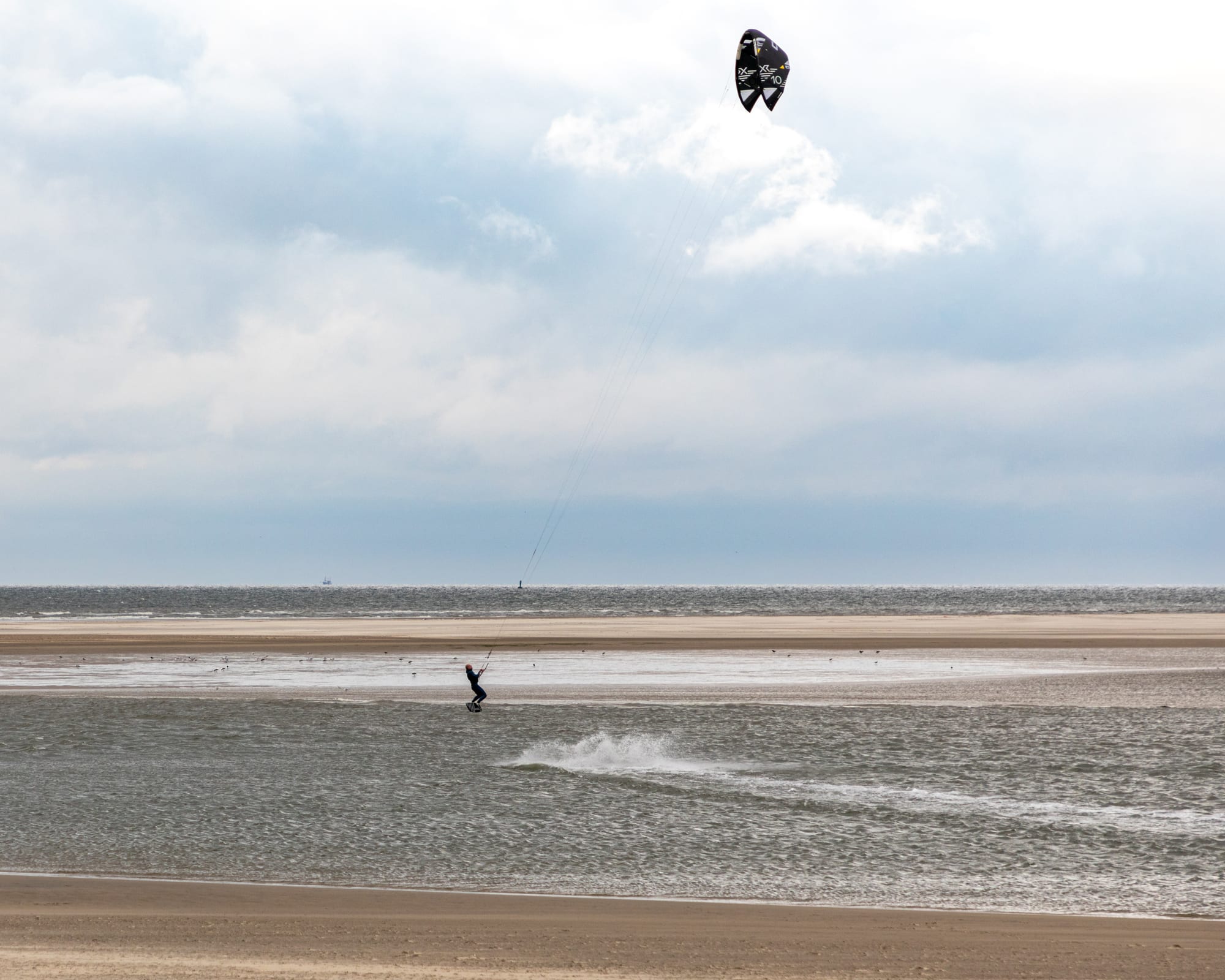 Kitesurfer vor dem breiten Sandstrand der Insel Borkum an der Nordsee